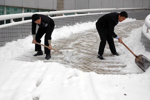 �Ϸ��ػ��ط������ĵĹ�����Ա����ɨ·�ϵĻ�ѩ��Ϊ�����ϰ�����׼����