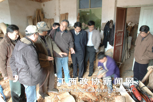 罗春明(左3)在工作室向《光华时报》采编人员介绍自己的作品