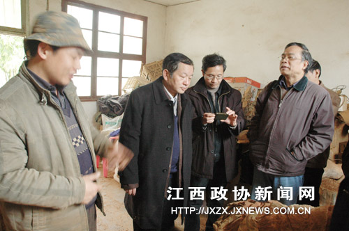 罗春明(左1)在工作室向《光华时报》采编人员介绍自己的作品